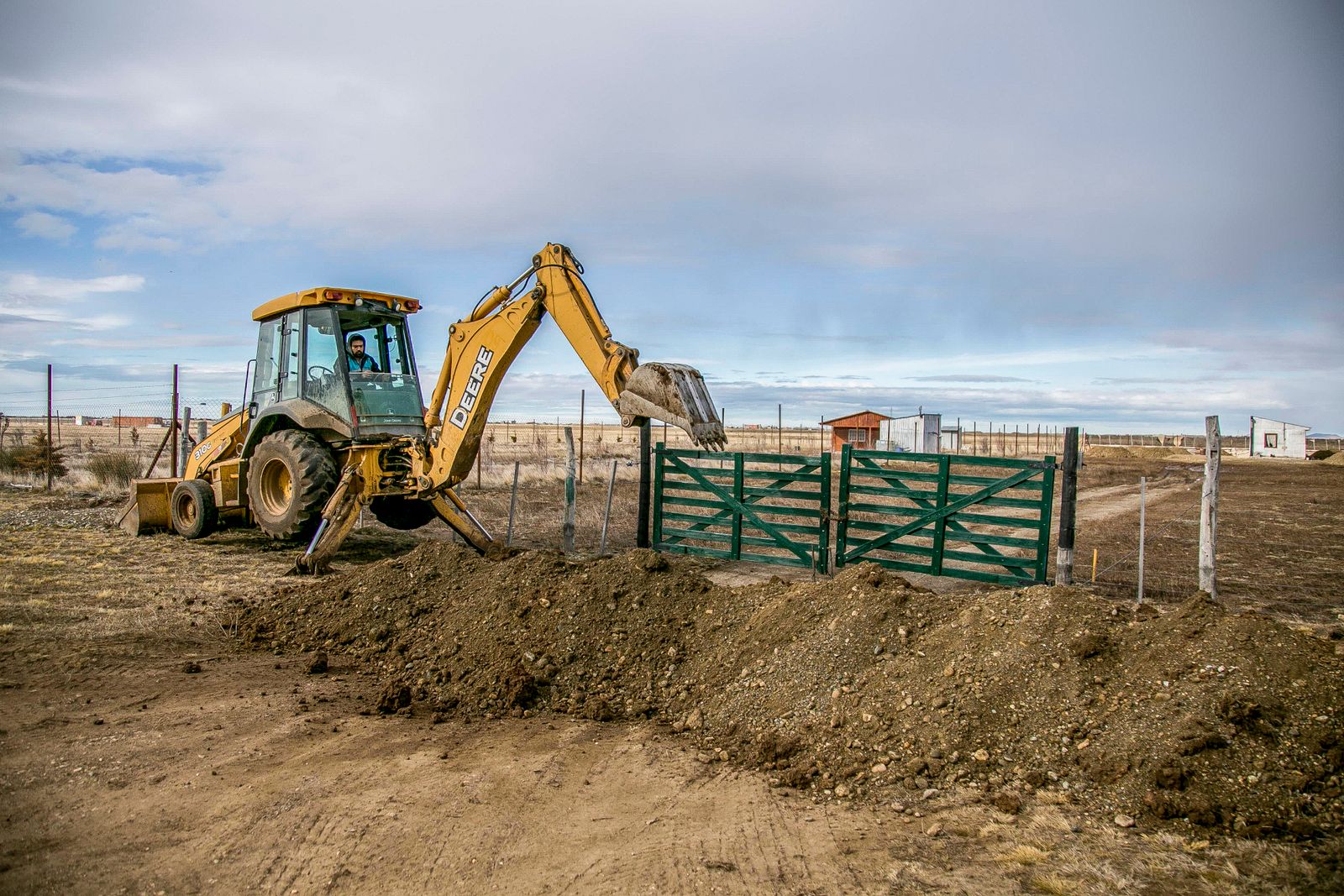 Backhoe excavating open ground on a rural lot