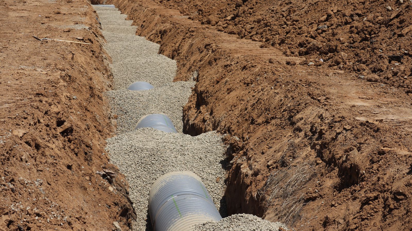 Drainage pipe bedded in gravel in an open trench