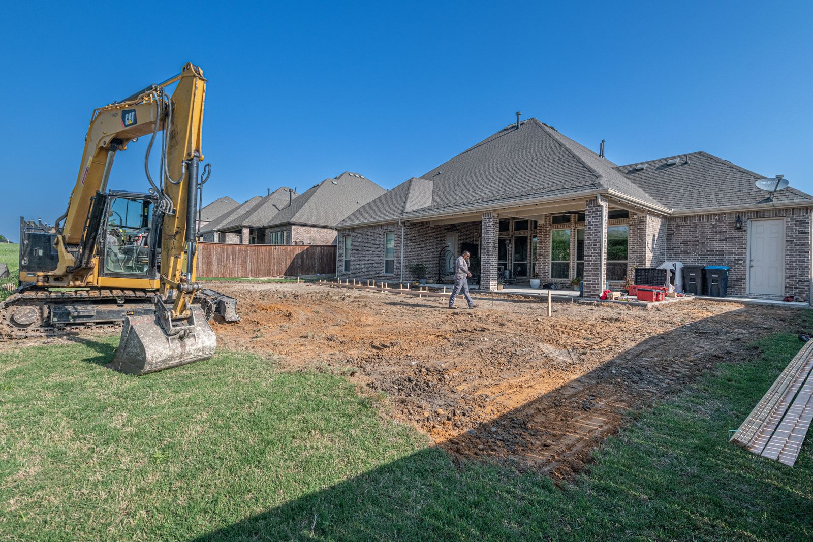Concrete septic tank being lowered into an excavated hole
